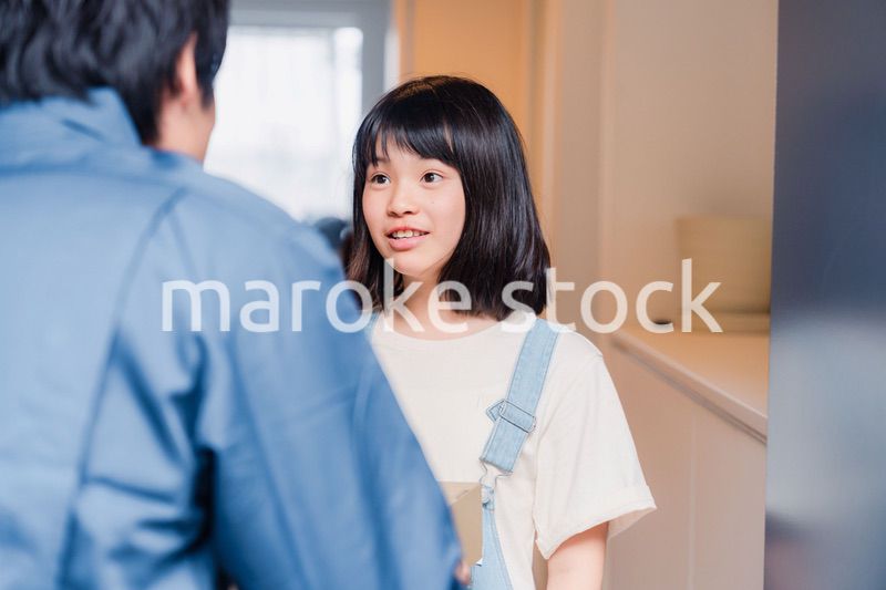 家で宅配便を受け取る小学生の女の子