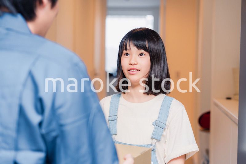 家で宅配便を受け取る小学生の女の子