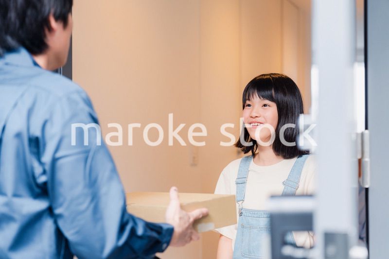 家で宅配便を受け取る小学生の女の子