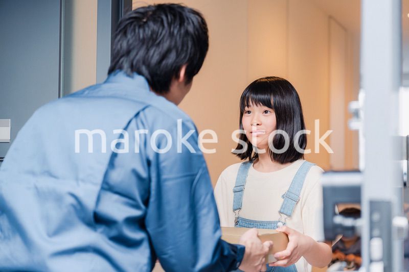 家で宅配便を受け取る小学生の女の子