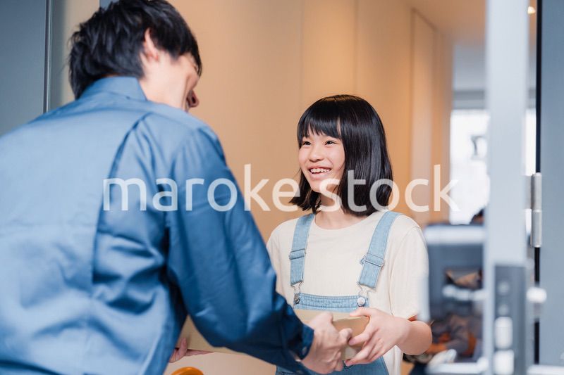 家で宅配便を受け取る小学生の女の子