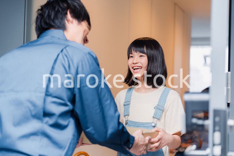 家で宅配便を受け取る小学生の女の子