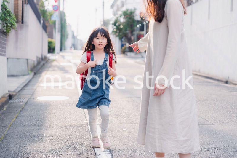 小学生の女の子のお迎えをするお母さん