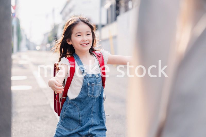 ランドセルを背負ってお母さんのところに走ってくる小学生の女の子