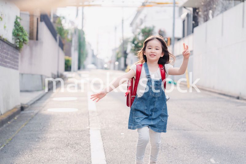 ランドセルを背負ってお母さんのところに走ってくる小学生の女の子