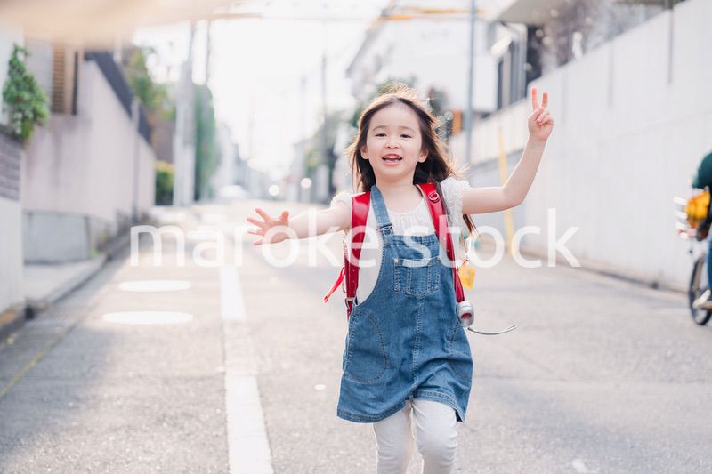 ランドセルを背負ってお母さんのところに走ってくる小学生の女の子