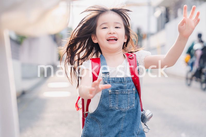 ランドセルを背負ってお母さんのところに走ってくる小学生の女の子