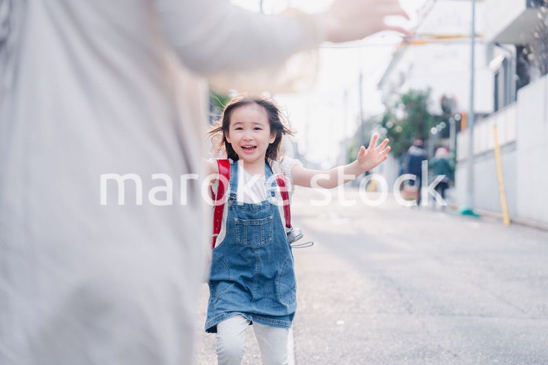 ランドセルを背負ってお母さんのところに走ってくる小学生の女の子