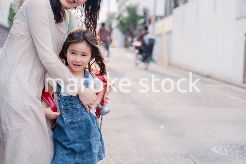 小学生の女の子のお迎えをするお母さん