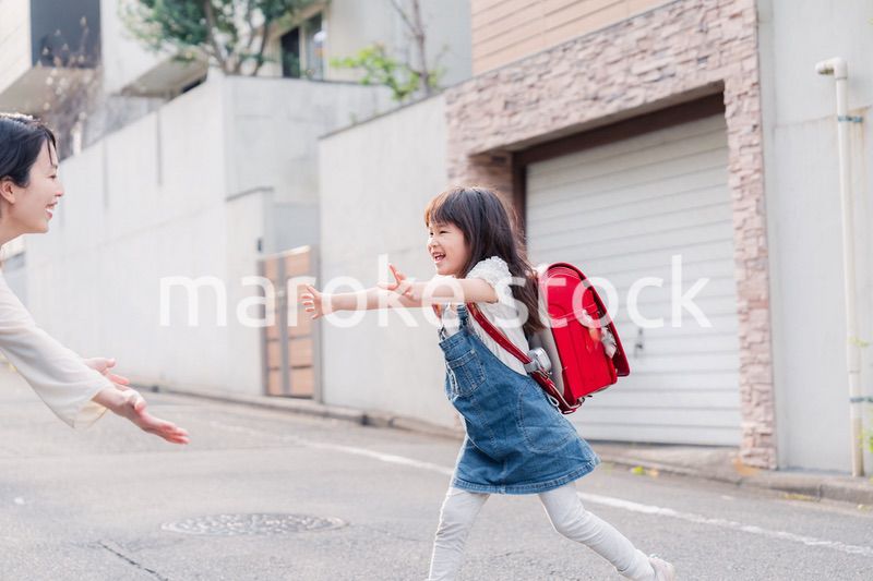 小学生の女の子のお迎えをするお母さん