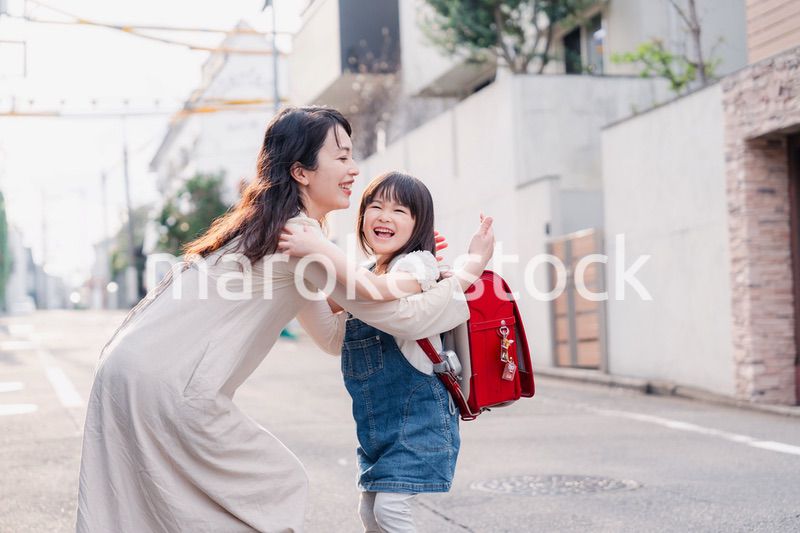 小学生の女の子のお迎えをするお母さん