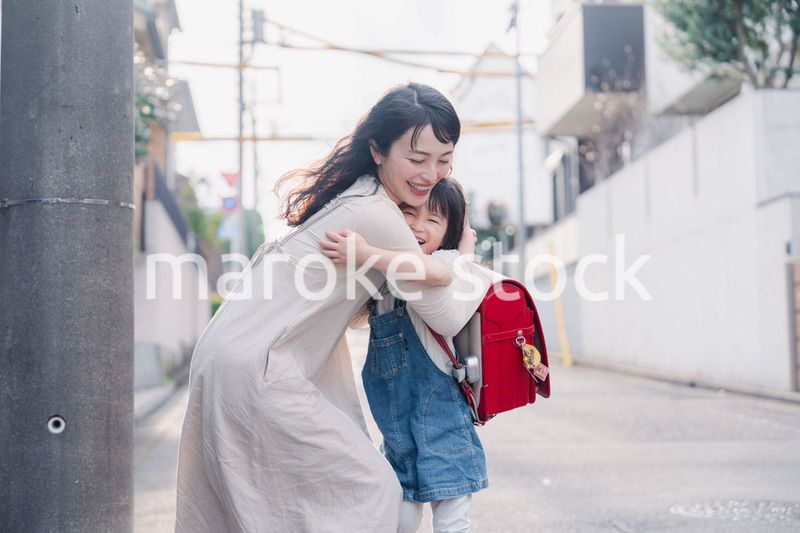 小学生の女の子のお迎えをするお母さん