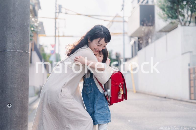 小学生の女の子のお迎えをするお母さん