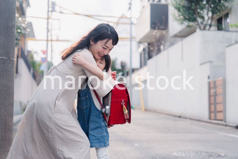 小学生の女の子のお迎えをするお母さん