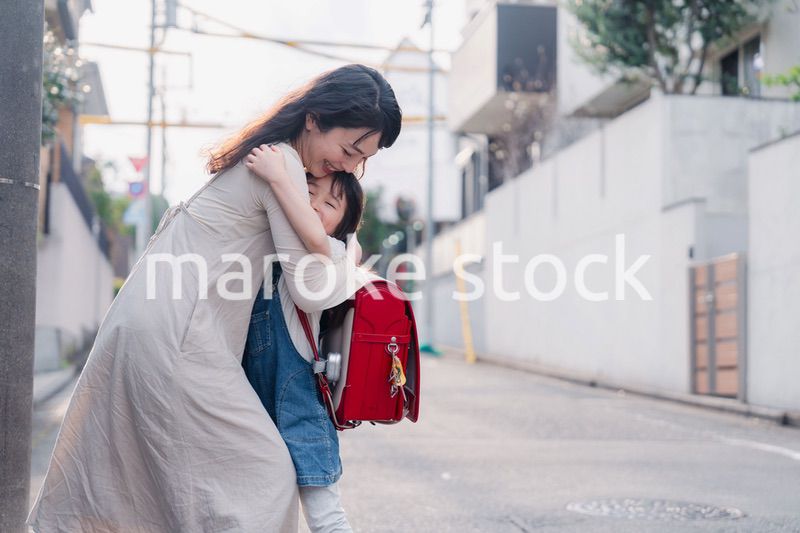 小学生の女の子のお迎えをするお母さん