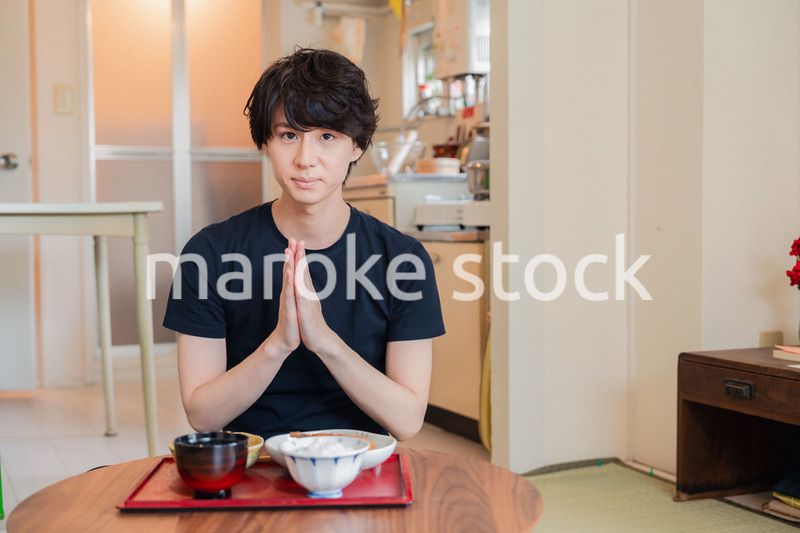 一人暮らしの下宿先でごはんを食べる若い男性
