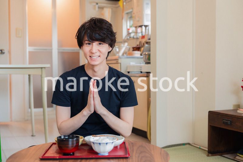 一人暮らしの下宿先でごはんを食べる若い男性