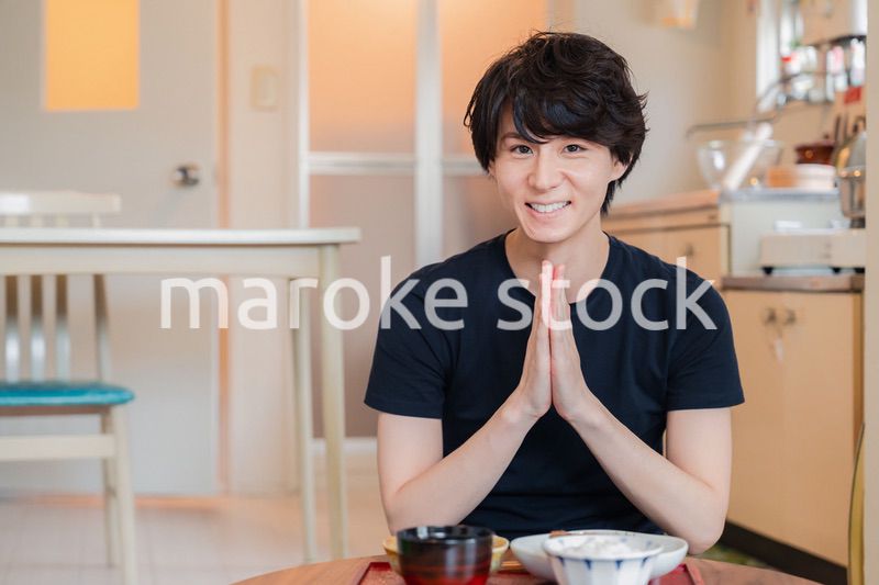 一人暮らしの下宿先でごはんを食べる若い男性