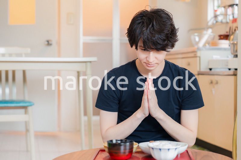 一人暮らしの下宿先でごはんを食べる若い男性