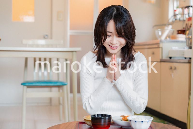 質素な家でごはんを食べる一人暮らしの女性