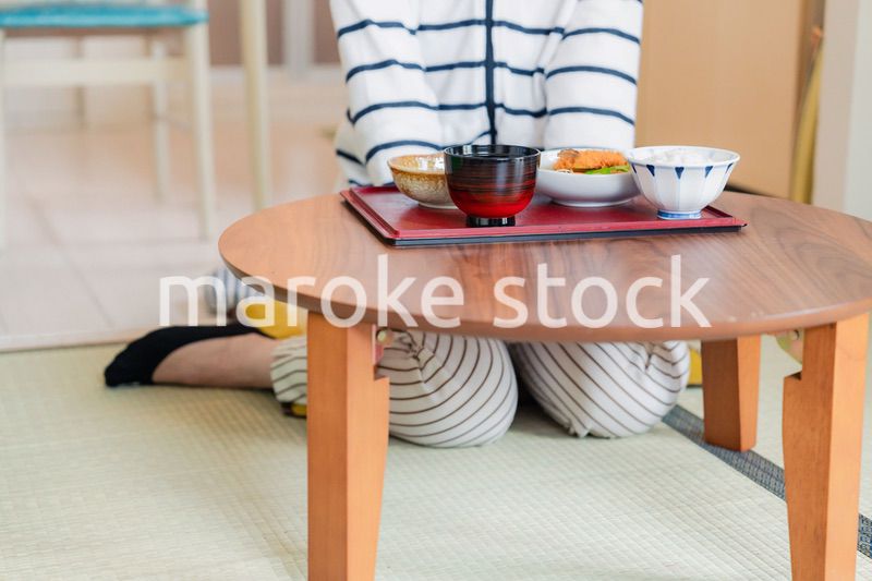 質素な家でごはんを食べる一人暮らしの女性