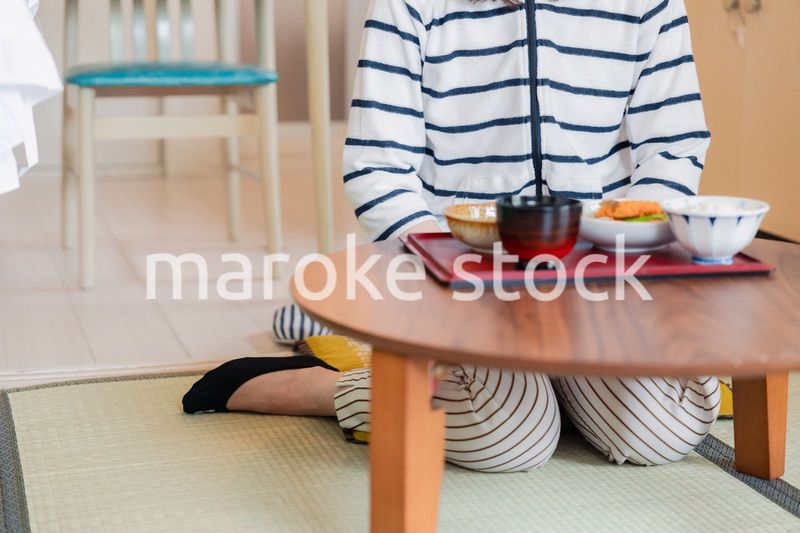 質素な家でごはんを食べる一人暮らしの女性