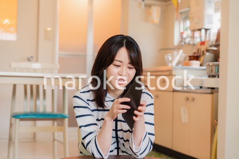 財布の中を確認して落ち込む若い女性