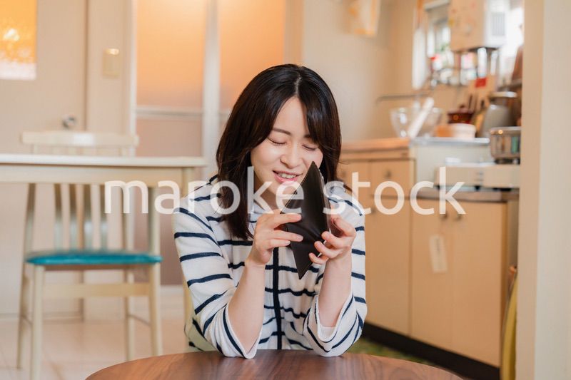 財布の中を確認して落ち込む若い女性