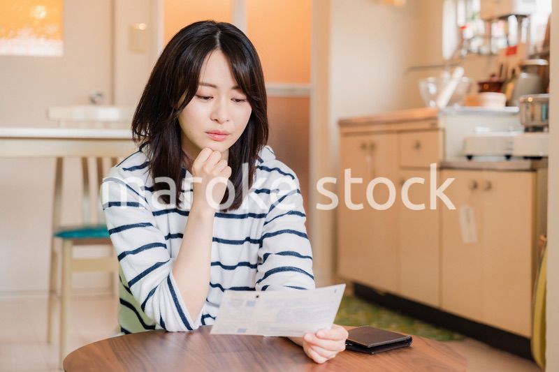 電気料金の高騰で頭を抱える若い女性