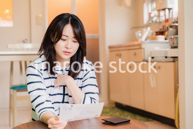 電気料金の高騰で頭を抱える若い女性