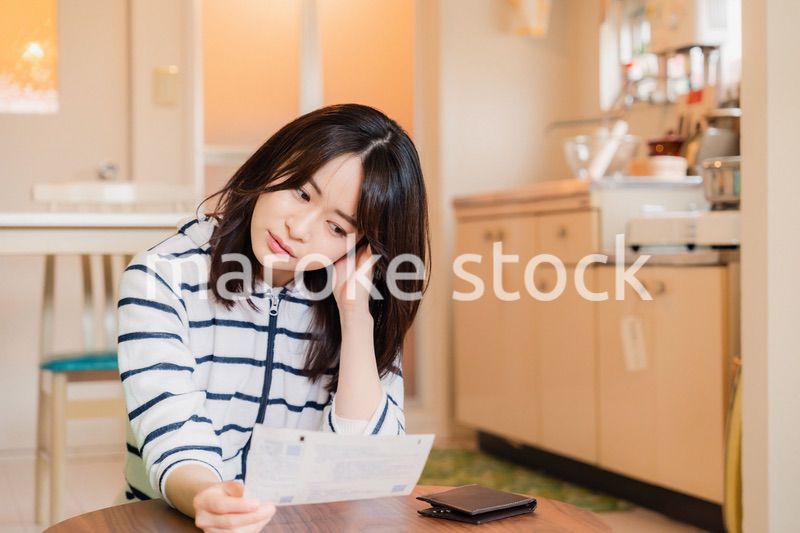 電気料金の高騰で頭を抱える若い女性
