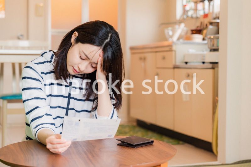 電気料金の高騰で頭を抱える若い女性