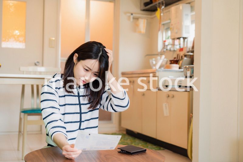 電気料金の高騰で頭を抱える若い女性