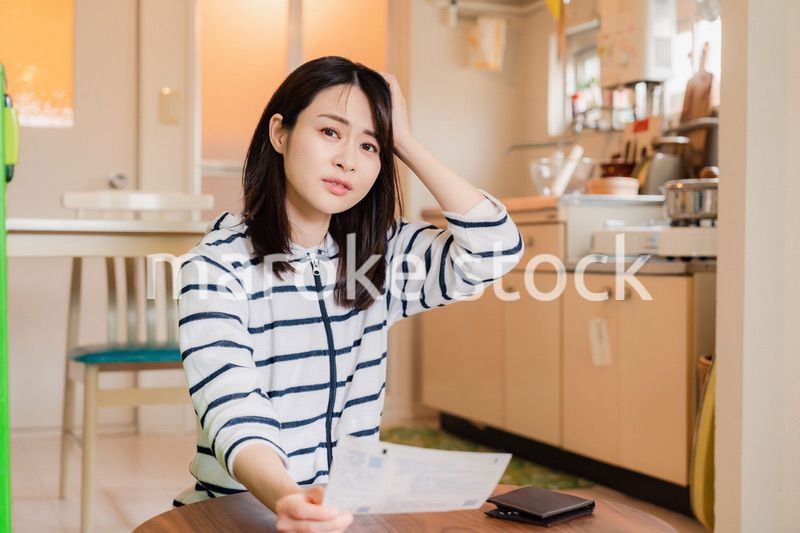 電気料金の高騰で頭を抱える若い女性
