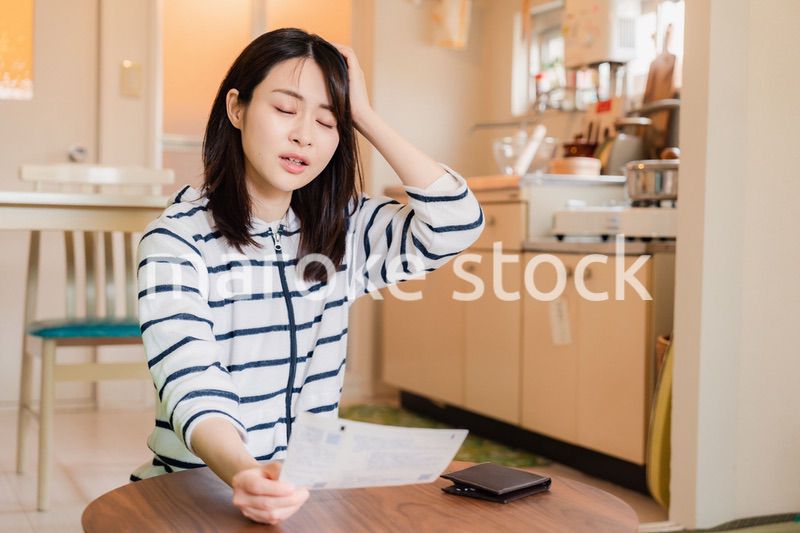 電気料金の高騰で頭を抱える若い女性