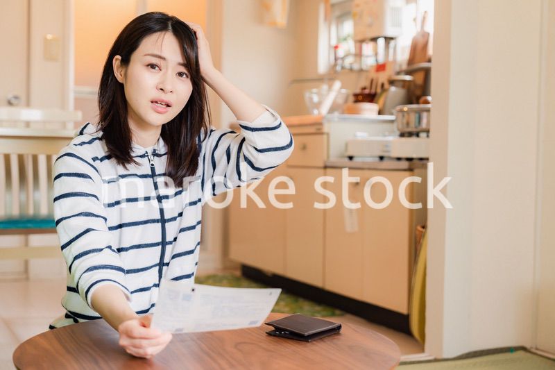 電気料金の高騰で頭を抱える若い女性