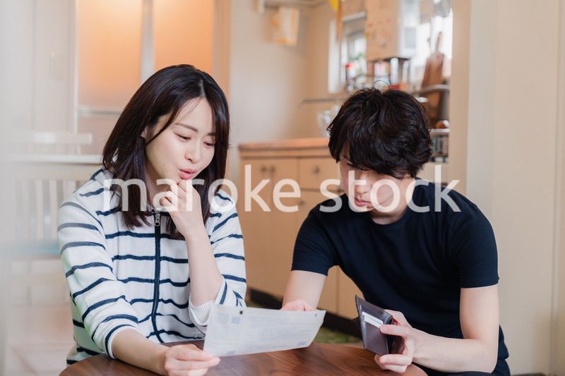 請求書明細を見て値上げに苦しむ若い夫婦