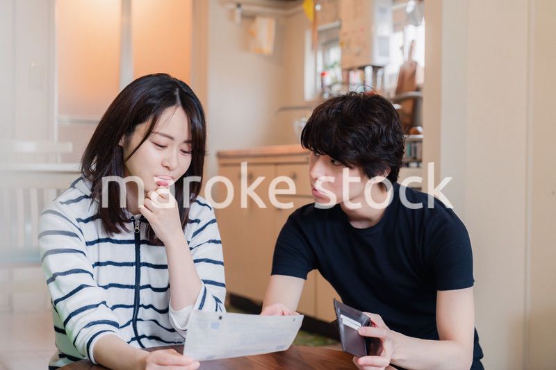 請求書明細を見て値上げに苦しむ若い夫婦