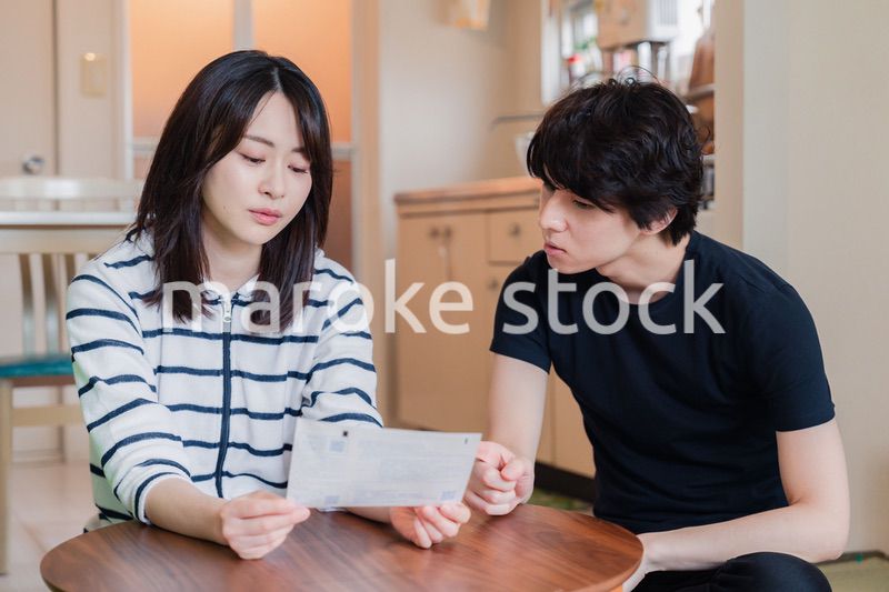 請求書明細を見て値上げに苦しむ若い夫婦