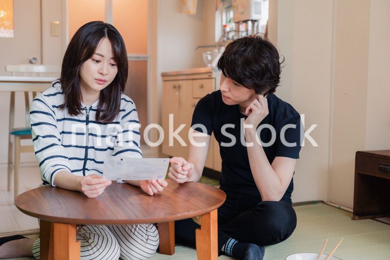 請求書明細を見て値上げに苦しむ若い夫婦