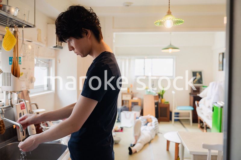 家事をする夫と後ろでサボる妻