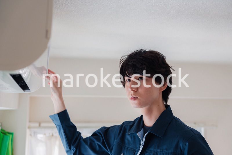 エアコンの点検をする男性