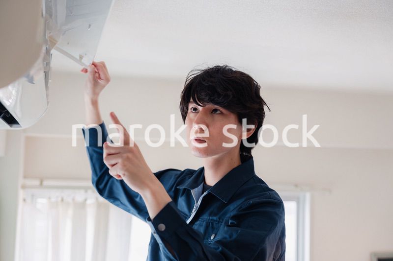 エアコンの点検をする男性