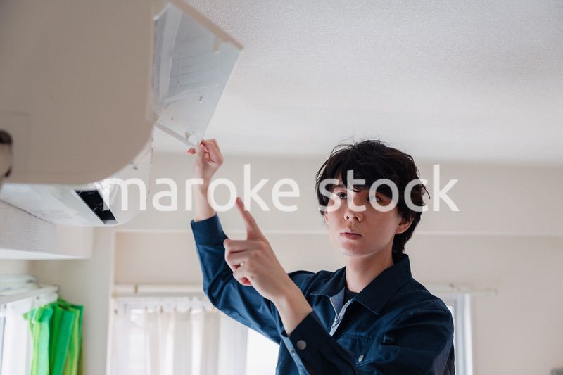 エアコンの点検をする男性