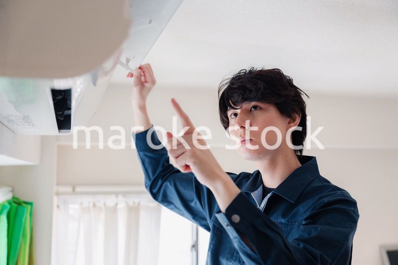 エアコンの点検をする男性