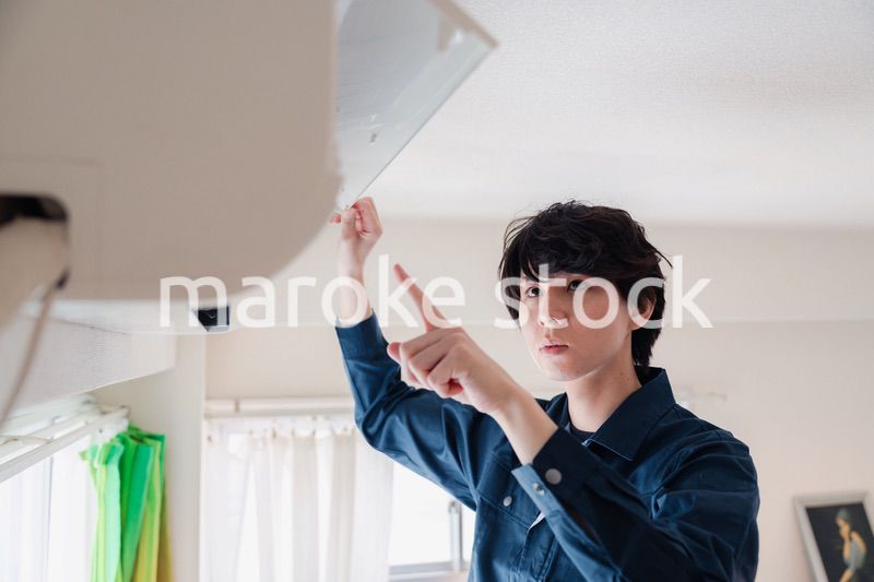 エアコンの点検をする男性