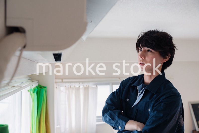 エアコンの点検をする男性