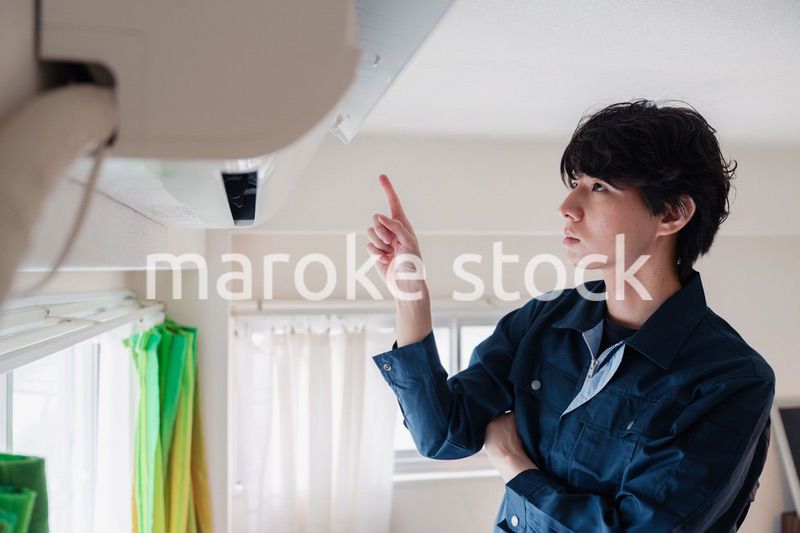 エアコンの点検をする男性