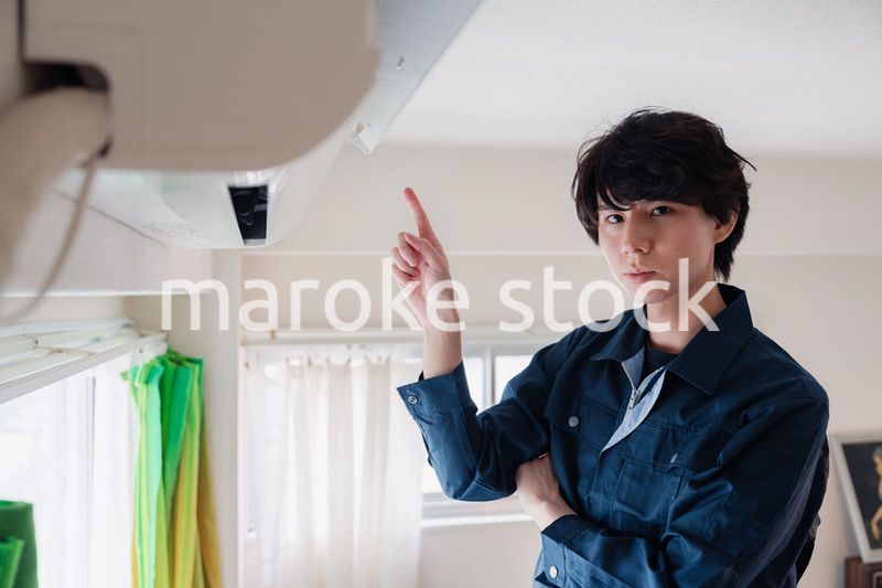 エアコンの点検をする男性