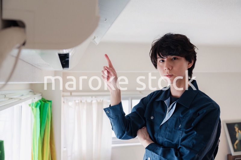 エアコンの点検をする男性